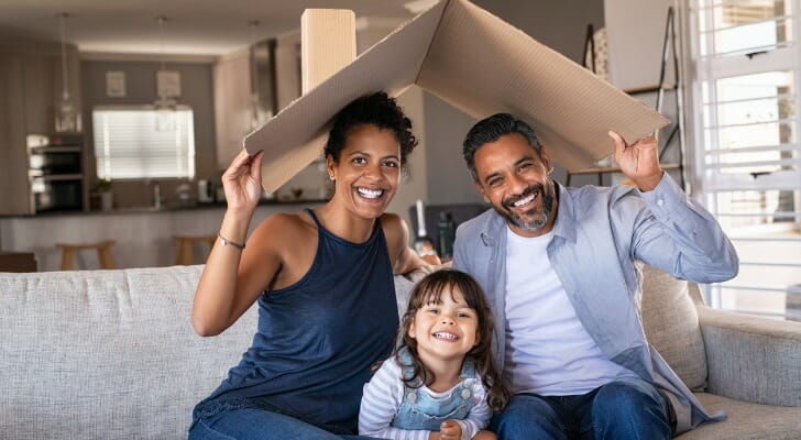 happy multiethnic family with child holding cardboard roof picture id1270066435 1